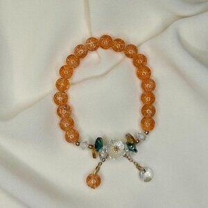 Orange beaded bracelet with a white flower charm!